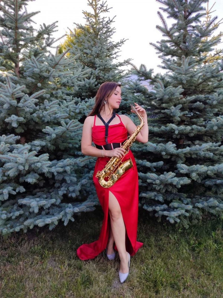 Розкішне музичне шоу саксофоністки Iva Sax на відкритому майданчику біля Київського моря в ефектній червоній концертній сукні