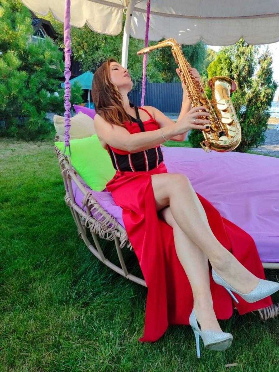 Віртуозний виступ Iva Sax на відкритому повітрі біля Київського моря для розкішної приватної вечірки — червона сукня та золотистий саксофон.