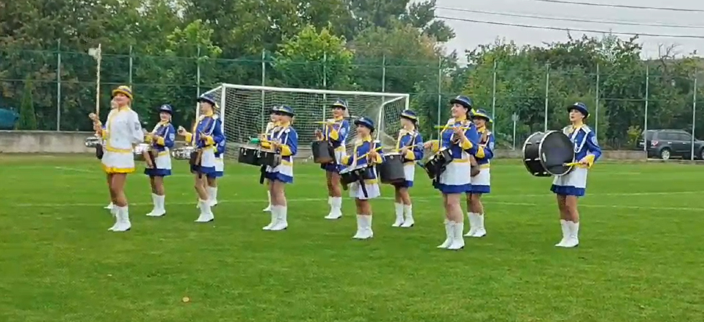 Ансамбль професійних барабанщиць виступає на футбольному полі перед глядачами, ефектна постановка для спортивного заходу