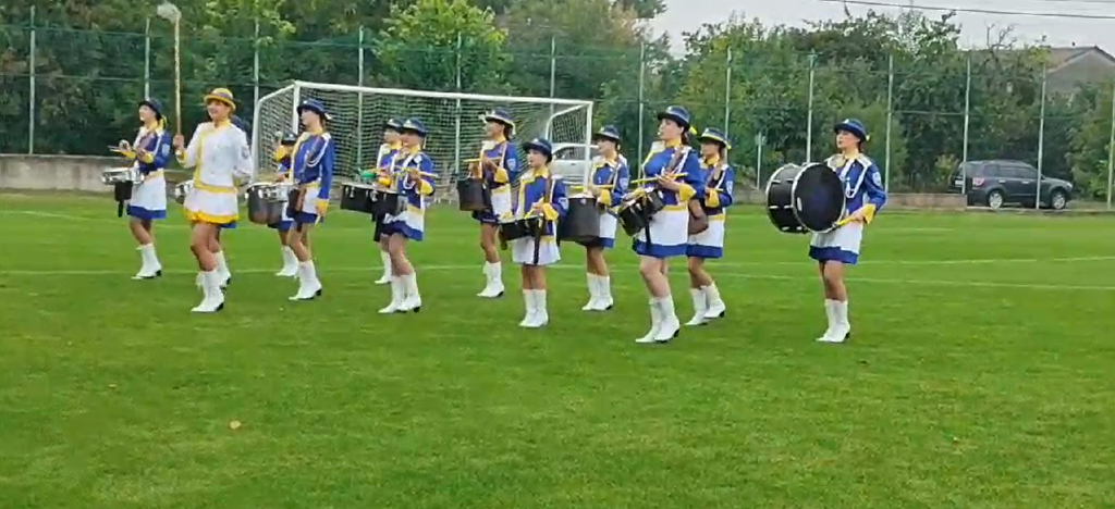 Енергічне барабанне представлення київських артисток на футбольній події, синьо-жовто-білі костюми та тамбур-мажор